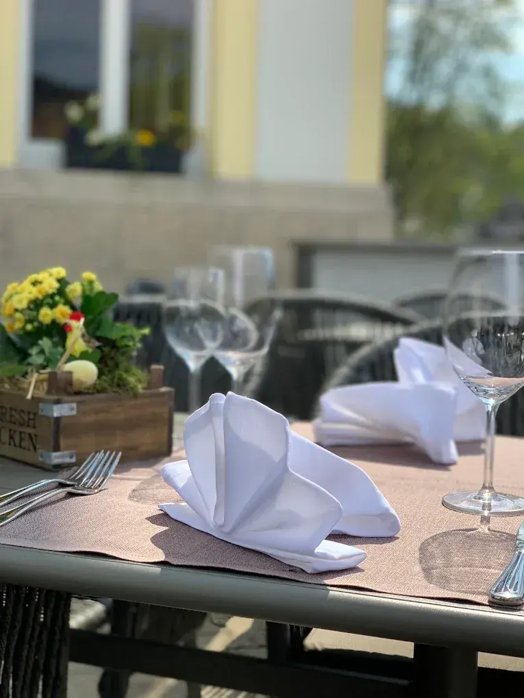 Weingläser und Servietten auf einem Terrassentisch im Grünen Baum Haslach